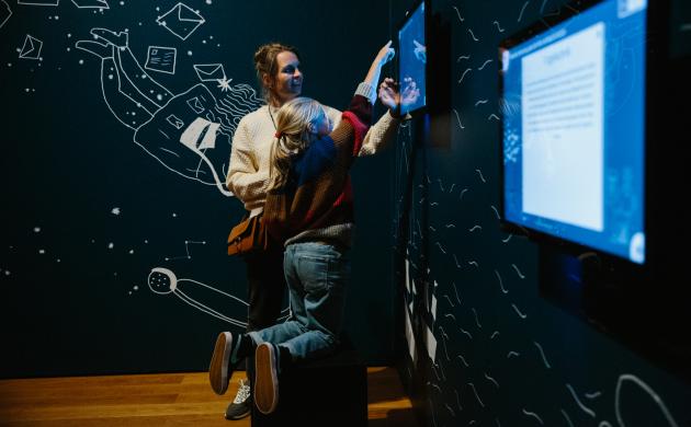 vrouw en kind kijken naar een scherm